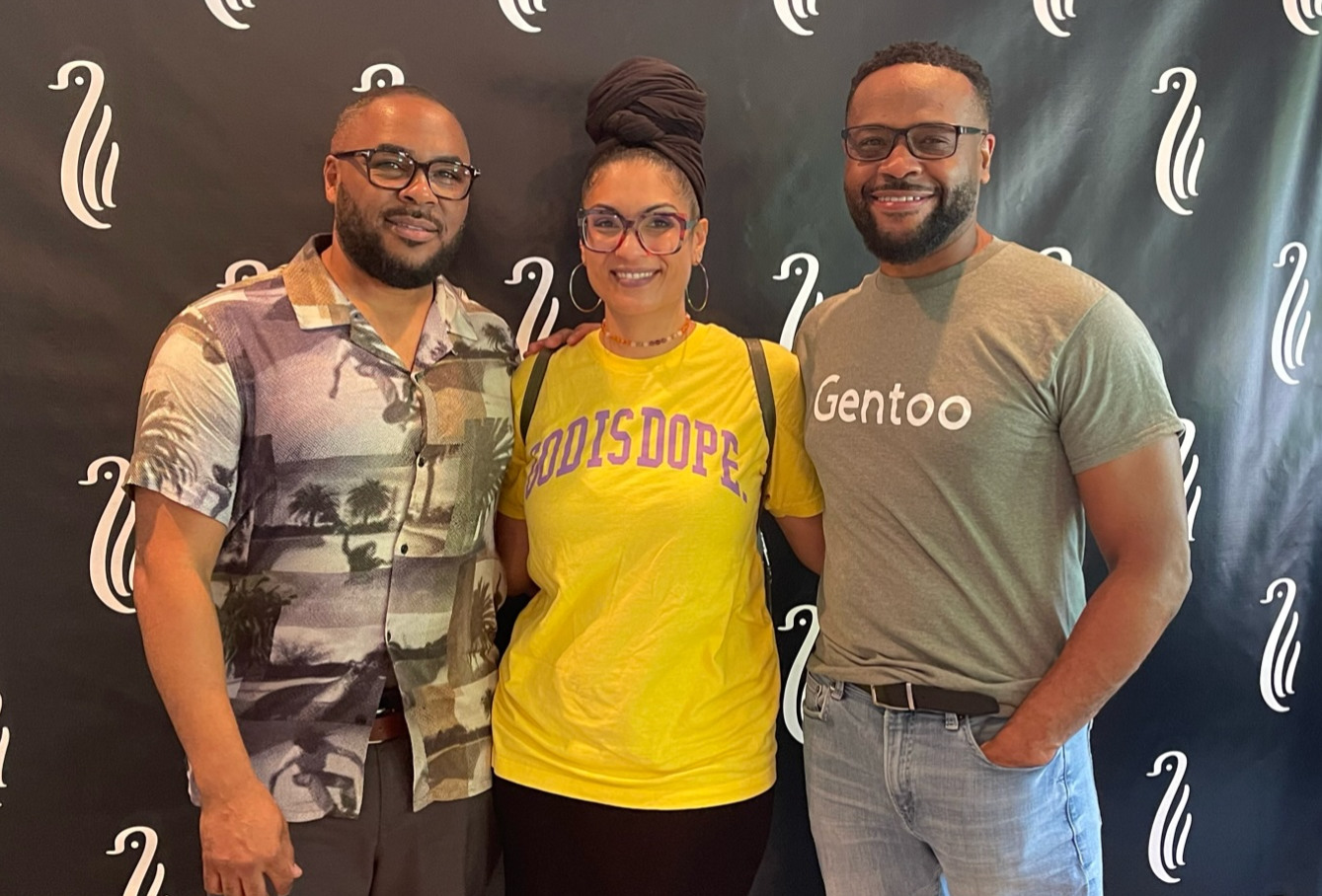 Three family members together in front of the Gentoo backdrop in 2023